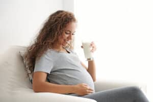Mujer en embarazo tomando un baso con leche